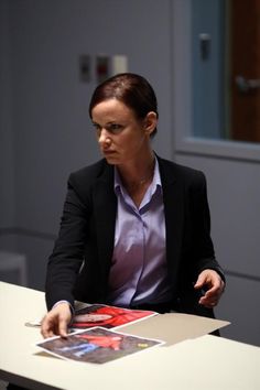 a woman sitting at a table with a book