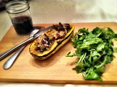 a wooden cutting board topped with food next to a salad