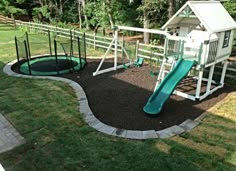 a play area with a slide, swing set and climbing frame in the back yard