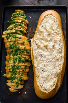 two breads with different types of food on top of each other, one is cut in half and the other has chopped parsley