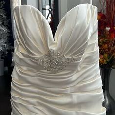 a white wedding dress on display in front of a mirror