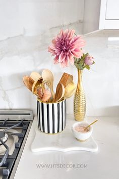 a vase filled with flowers sitting on top of a counter next to a burner