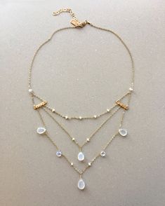 "Handmade beautiful triple chain \"Mediterranean Necklace\" made with real faceted teardrop briolette moonstones. Great piece to wear as a bride or bridesmaid or any special occasion. Fills neckline and chest beautifully and shimmers in the light. Natural genuine moonstones vary in color from milky white to an iridescent clear and match nicely with the white fresh water pearls. Tiny fresh water pearls create the first layer of chain strand which falls closest to neck. There is a  small hammered bar on each side that connect all three chains below, creating space in between each one.  Finished with an adjustable extender chain, can be worn at several different lengths. Measurements: Can be worn as choker or longer  Lowest Chain Drops to mid - lower chest Handmade Jewelry Sarah Healy Design Moonstone Gemstone Necklace For Wedding, White Bohemian Jewelry With Delicate Chain, Bohemian Teardrop Necklace For Weddings, Bohemian Delicate Chain Jewelry For Weddings, Wedding Moonstone Gemstone Necklace, Bohemian Drop Jewelry For Wedding, Wedding Moonstone Jewelry With Faceted Details, Bohemian Delicate Chain Wedding Jewelry, Bohemian Wedding Jewelry With Delicate Chain