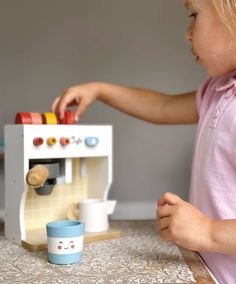 This set includes a wooden coffee maker unit with 4 squishy buttons, a coffee pod holder, 3 coffee pods, a wooden takeaway cup with removable lid, and a pretend milk jug. Age range: 3 years+ Product size: 5.71 x 5.51 x 6.69’’ Weight: 1.72 Ibs Coffee Pod Holder, 3 Coffee, Real Coffee, Espresso Drinks, Childhood Development, Non Toxic Paint, Milk Frother, Toy Kitchen, Coffee Pods