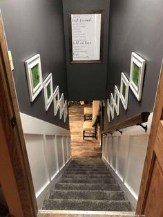 an open door leading to a hallway with pictures on the wall and carpeted stairs