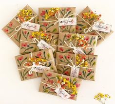 small gift boxes with tags tied to them and flowers painted on the side, sitting next to each other