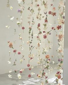 an art installation with flowers hanging from the ceiling