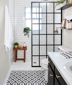 a black and white tiled bathroom with an open shower door