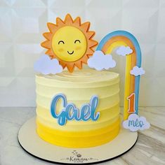 a yellow cake with the word geli on it and a smiling sun topper