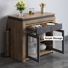 an open cabinet with dishes in it on the floor next to a vase and flowers