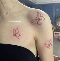 two butterflies on the back of a woman's left shoulder and right arm, both with red ink