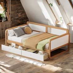 a bed with two drawers underneath it in a room that has wooden floors and white walls