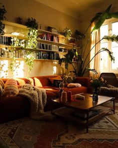 a living room filled with furniture and lots of plants