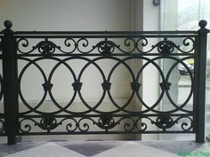 an ornate iron gate in the corner of a room with white walls and flooring