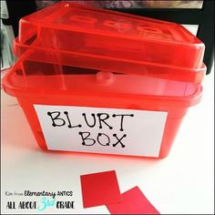 a red plastic box with two pieces of paper in it and the words blurt box next to it