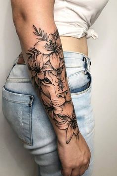 a woman's arm with flowers and a giraffe tattoo on her left arm