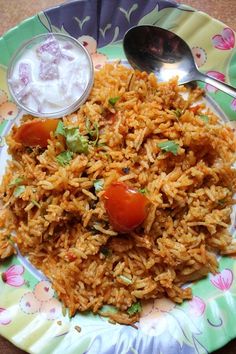 a plate full of rice and vegetables with a side of yogurt on the side