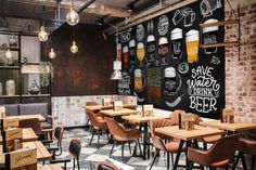 the interior of a restaurant with wooden tables, chairs and chalkboard on the wall