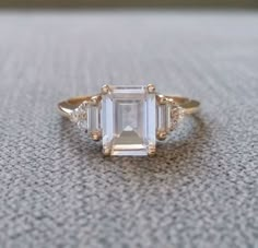 an emerald cut diamond ring with three side stones