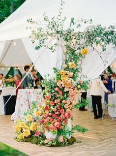 an arrangement of flowers is on display under a tent