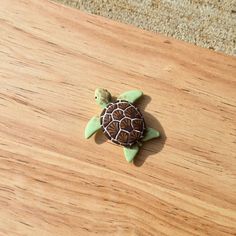 a small turtle sitting on top of a wooden table