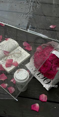 a box filled with pink roses on top of a wooden table next to a knife