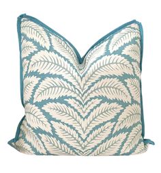 a blue and white pillow with leaves on it