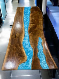 a wooden table with blue water painted on the top and bottom, in a store