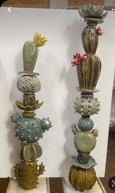 two tall cactus vases sitting on top of each other