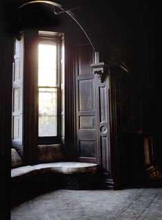 an open door and window in a dark room with sunlight coming through the window,