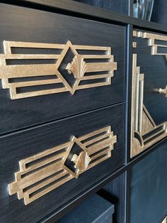 two black drawers with gold designs on the front and side panels, one inlaid to each other