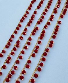 red beads and gold chains on a white surface