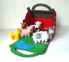 there is a felt bag with animals and farm animals in it on the table next to some toys