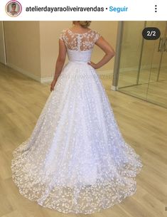 a woman in a white wedding dress looking at herself