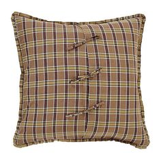 a brown plaid pillow sitting on top of a white wall