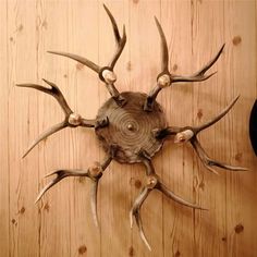 a clock made out of antlers on a wooden wall