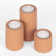 three candles sitting next to each other on a white surface