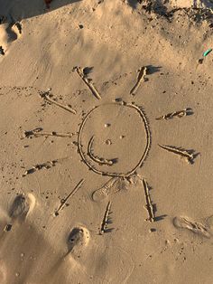 the sun is drawn in the sand and it looks like someone has made a face