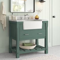 a white sink sitting under a bathroom mirror next to a green cabinet and counter top