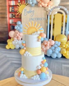 a three tiered cake decorated with balloons