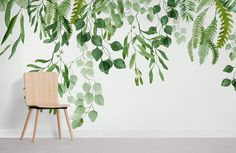 a chair sitting in front of a wall with green leaves on it