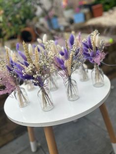 small vases filled with purple and white flowers