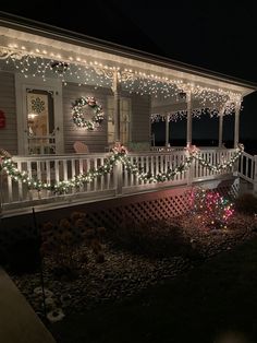 a porch covered in christmas lights with wreaths on the front and side of it