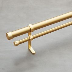 a pair of gold - plated metal objects on a gray surface, including two handles and one handle