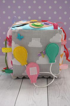 a gray and white bag with hot air balloons on the front is sitting on a wooden floor