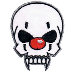 a white skull with black eyes and red ball in it's mouth embroidered on a white background