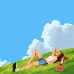 a woman laying in the grass next to a ukulele on top of a hill