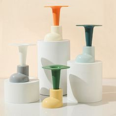 three different colored vases sitting next to each other on top of a white table