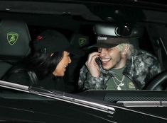 a man talking on a cell phone next to a woman in a car