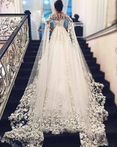 a woman in a wedding dress standing on stairs